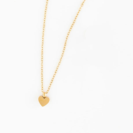Gold heart necklace and earrings on a white background